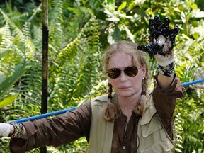 Actress Mia Farrow shows her gloved hand covered with oil during a visit to the Aguarico field in the Ecuadorean Amazonia region, Aguarico, Ecuador this year. Farrow was in Ecuador to support government's campaign against Chevron Corp.