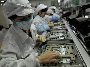 Chinese workers assemble electronic components at the Taiwanese technology giant Foxconn's factory in Shenzhen, in the southern Guangzhou province.
