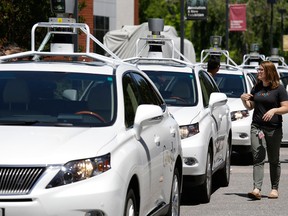 A row of Google self-driving Lexus cars at an event outside the Computer History Museum in Mountain View, Calif.
