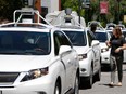 A row of Google self-driving Lexus cars at an event outside the Computer History Museum in Mountain View, Calif.