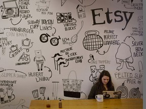 An employee works while sitting under a mural at Etsy Inc. headquarters in the Brooklyn borough of New York, U.S., on Monday, May 4, 2015. Etsy Inc., a marketplace for handmade and vintage goods, raised $267 million in its initial public offering. Photographer: Victor J. Blue/Bloomberg