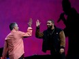 Apple's senior vice president of Internet Software and Services Eddy Cue (L) high fives with recording artist Drake during the initial Apple Music introduction