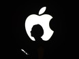 A person walks by an Apple logo