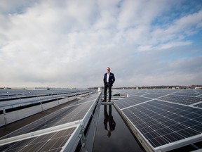 Steven Muzzo, founder and chief executive of the Ozz Group, stands amid the solar panels on the roof of the company's office in Concord, Ontario.