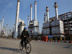 An Iranian oil worker rides his bicycle at the Tehran's oil refinery south of the capital Tehran.