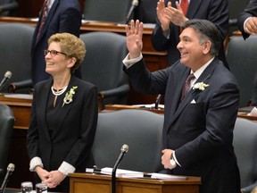 Ontario Finance Minister Charles Sousa, right, waves prior to delivering the Ontario budget at Queen's Park