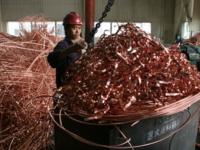 A Chinese worker handles copper bits and pieces at Shanghai LongYang Precise Compound Copper Tube Co., Ltd.of GD Copper in Shanghai, China.