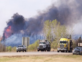 Flames flare up from hotspots along the highway to Fort McMurray, Alta., on Sunday, May 8, 2016. THE CANADIAN PRESS/Ryan Remiorz ORG XMIT: RYR104
