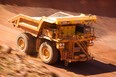 An autonomous haul truck drives through a pit of the Rio Tinto West Angelas iron ore mine in Australia.