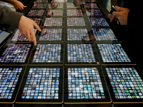 Developers look over new apps being displayed on iPads at the Apple Worldwide Developers Conference in San Francisco