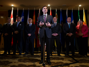 Federal Finance Minister Bill Morneau, centre, is flanked by his provincial and territorial counterparts as he speaks during a news conference after reaching a deal to expand the Canada Pension Plan.