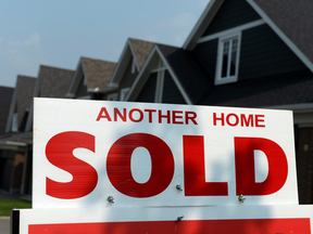 A 'for sale' sign displays a sold home in a development