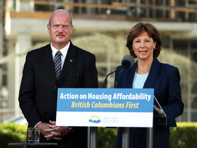Premier Christy Clark and Finance Minister Michael de Jong, discuss amendments regarding housing issues in Greater Vancouver from the South lawn during a press conference at the Legislature in Victoria, B.C., Monday, July 25, 2016.