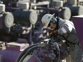 A worker oils a pump during a hydraulic fracturing operation at an Encana Corp. well pad near Mead, Colo.