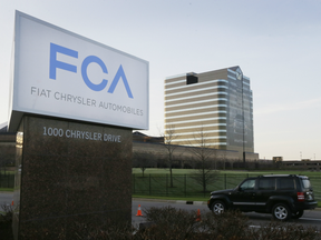 A vehicle moves past a sign outside Fiat Chrysler Automobiles world headquarters in Auburn Hills, Mich