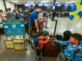 Passengers check-in at Newleaf, Canada’s latest discount airline before its inaugural flight out of Hamilton on July 25, 2016.