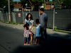 Loraine Adal-Salmon (top, left) and Anthony Salmon (top, right) pose for a portrait with their daughters Isabel (left) and Olivia (right) in front of the land which was supposed to become their new home