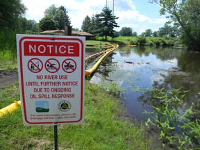 A sign at the confluence of Talmadge Creek and the Kalamazoo River warns residents of the oil spill in July 2010.