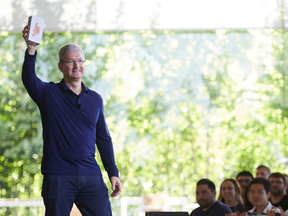 Apple Inc. CEO Tim Cook holds the billionth iPhone at an employee meeting in Cupertino, California.