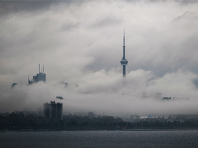 Fog rolls in front of the CN Tower and skyline in Toronto