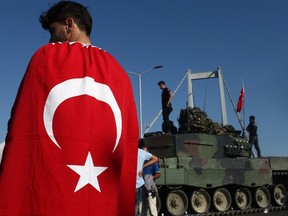 People gather for celebration around Turkish police officers, loyal to the government, standing atop tanks abandoned by Turkish army officers, against a backdrop of Istanbul's iconic Bosporus Bridge in Istanbul, July 16, 2016, Turkey. Istanbul's bridges across the Bosphorus, the strait separating the European and Asian sides of the city, had been closed to traffic.Turkish President Recep Tayyip Erdogan has denounced an army coup attempt, that has left atleast 90 dead 1154 injured in overnight clashes in Istanbul and Ankara.