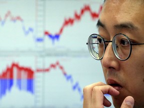 A currency trader watches monitors at the foreign exchange dealing room of the KEB Hana Bank headquarters in Seoul, South Korea, Tuesday.