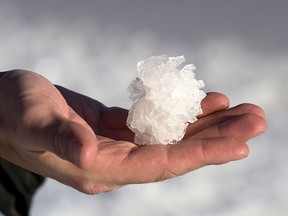 A man displays a salt crystal collected from a dried pond where sea water evaporates and sodium chloride is obtained.
