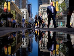 People walk through downtown Calgary. As many as 60,000 energy professionals laid off in Alberta since the beginning of the oil price downturn.