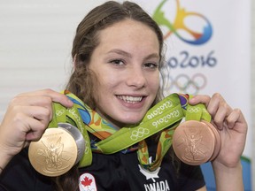 Penny Oleksiak, from Toronto, holds up her four medals, a gold, silver and two bronze, which she won at the 2016 Summer Olympics.