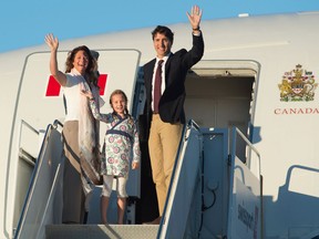 Prime Minister Justin Trudeau, his wife Sophie Gregoire, and daughter Ella-Grace wave as they board a government plane to leave for China.