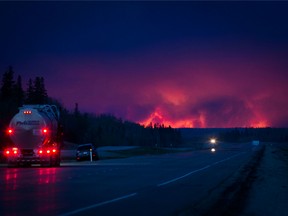 A truck drives on a highway as a wildfire burns south of Fort McMurray, Alberta, Canada, on May 4, 2016.