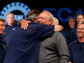 Fiat Chrysler Automobiles CEO Sergio Marchionne, left, and United Auto Workers President Dennis Williams hug during a ceremony to mark the opening of contract negotiations on July 14, 2015 in Detroit.