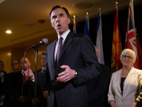 Federal Finance Minister Bill Morneau is flanked by his provincial and territorial counterparts as he speaks during a news conference