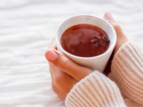 Women holds a cup of hot tea with anise star.