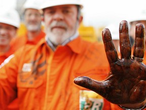 Former Brazilian President Luiz Inacio Lula da Silva with his hand dirty with pre-salt oil, collected at Capixaba oil plataform on Franca Whale oil field