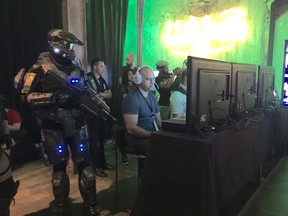 A Spartan supersoldier watches an attendee play his game at X16 in Toronto, August 25, 2016.
