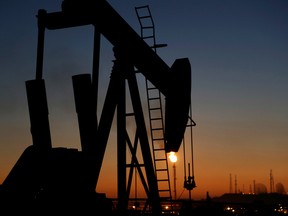 An oil pump works at sunset Monday, Jan. 18, 2016, in the desert oil fields of Sakhir, Bahrain