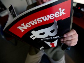 A man reading a copy of the new print edition of Newsweek magazine