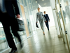 Employees at an office walk through its hallways.