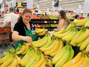 Walmart associate Amanda Thompson stocks fresh bananas at the Halifax Walmart Supercentre.