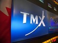 TMX Group Inc. signage and stock prices are displayed on a screen in the broadcast center of the Toronto Stock Exchange.