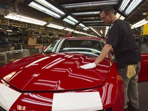 A worker checks the paint on a Camaro at the General Motors plant in Oshawa, Ont., in June, 2011.