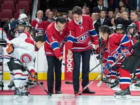 Chinese Premier Li Keqiang, centre left, and Canadian Prime Minister Justin Trudeau, centre right, drop the puck for a face-off in a friendly game amongst youth hockey players
