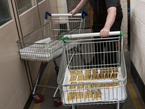 An employee moves gold and silver bars at the Baird & Co. Ltd. precious metals refinery in London, U.K.