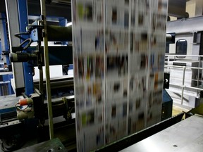 Printed pages of a newspaper roll through the printing machine.