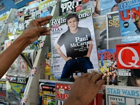 A vendor pulls out one of the Rolling Stone magazine on sale in Singapore on September 26, 2016.