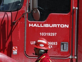 An unidentified worker passes a truck owned by Halliburton at a remote site for natural-gas producer Williams in Rulison, Colo.