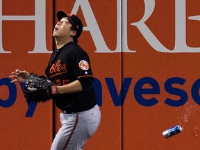 The toss seen round the social media world: Baltimore Orioles' Hyun Soo Kim gets under a fly ball as a beer can sails past him during seventh inning American League wild-card game action against the Toronto Blue Jays in Toronto.