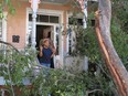 Sharon Kelsey, front, and her cousin, Pamela Williams, stand on the front port of the Victorian home in Savannah, Ga., where Kelsey lives. A large tree crashed across the front of the house as Hurricane Matthew raked the Georgia coast over the weekend.