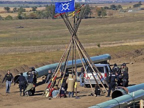 Law enforcement officers, left, drag a person from a protest against the Dakota Access Pipeline, near the town of St. Anthony in rural Morton County, North Dakota.